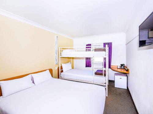 a hotel room with a bed and a desk at ibis Budget - Dubbo in Dubbo