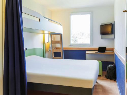 a room with two bunk beds and a television at Logis Hôtel de Port d'Alon - St Cyr sur Mer in Saint-Cyr-sur-Mer
