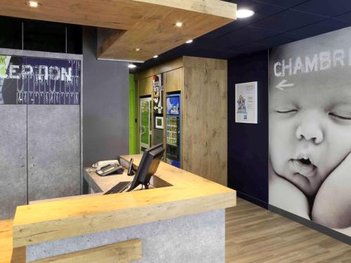 an office with a desk with a baby on the wall at Hotel Ibis Budget Nancy Centre in Nancy
