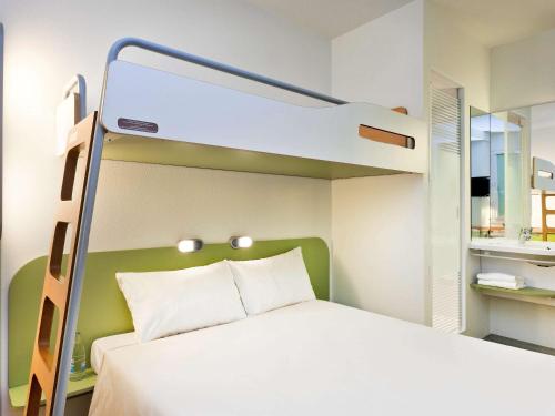 um quarto com um beliche e uma cama branca em ibis budget Orly Rungis em Rungis