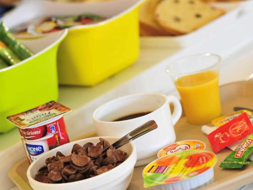 a tray with a cup of coffee and a bowl of food at ibis budget Orly Rungis in Rungis