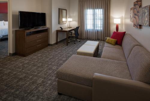 a living room with a couch and a tv and a desk at Staybridge Suites - Phoenix – Biltmore Area by IHG in Phoenix