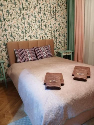 ein Bett mit zwei braunen Handtüchern darüber in der Unterkunft Apartament w trójmiescie in Kowale