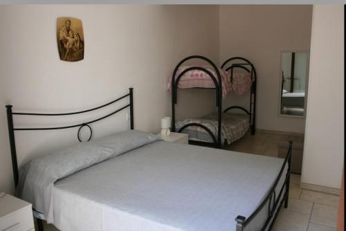 1 dormitorio con cama y espejo en casa vacanze la pizzica, en Palmariggi