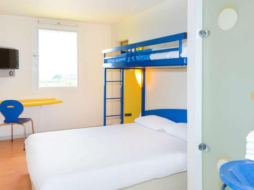 a bedroom with a bunk bed and a desk at ibis budget Nevers Varennes Vauzelles in Varennes Vauzelles