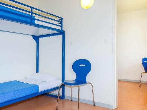 a bedroom with a bunk bed and a blue chair at ibis budget Nevers Varennes Vauzelles in Varennes Vauzelles