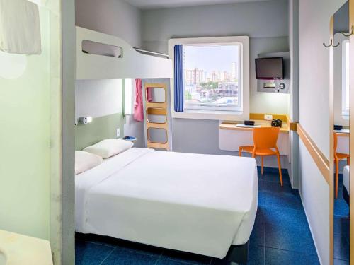 a hotel room with a bed and a desk and a room at ibis budget Belem in Belém