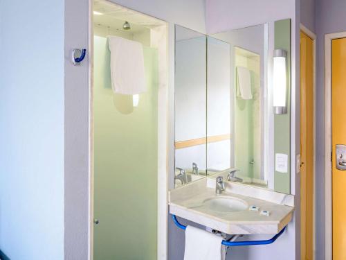 uma casa de banho com um lavatório e um espelho em ibis budget Belem em Belém