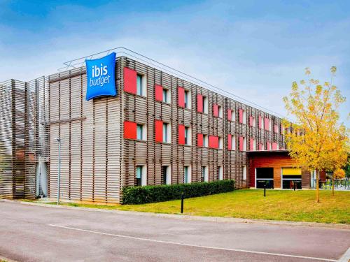 un edificio con una señal azul en el costado. en ibis budget Metz Technopole en Metz