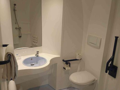 a small bathroom with a sink and a toilet at Ibis Budget Ancenis in Mésanger