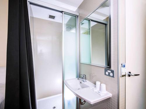 a bathroom with a sink and a shower at ibis Budget Sydney Olympic Park in Sydney