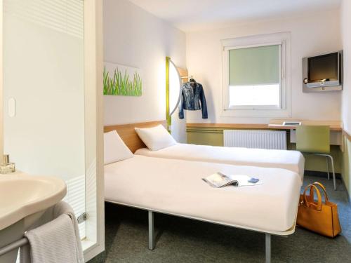 Habitación hospitalaria con 2 camas y lavamanos en ibis budget Loriol Le Pouzin, en Le Pouzin