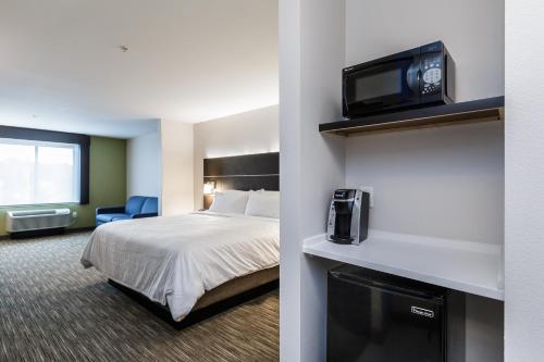 a hotel room with a bed and a tv on a wall at Holiday Inn Express & Suites- South Bend Casino by IHG in South Bend