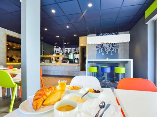 a breakfast table with food on it in a restaurant at ibis budget Pau Lescar in Lescar