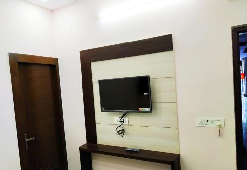 a flat screen tv on a wall in a room at Hotel vinayak inn in Haridwār