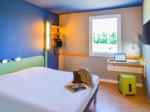 Un pat sau paturi într-o cameră la Ibis Budget Porte de Camargue