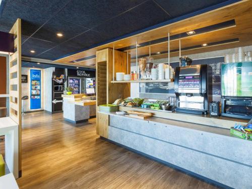 a fast food restaurant with a counter with food at Ibis budget Les Sables d'Olonne in Les Sables-dʼOlonne
