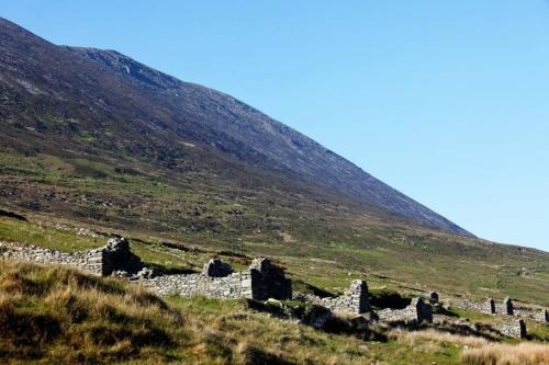 an old stone building in the middle of a hill at Ocean View one bedroom cozy apartment in Achill
