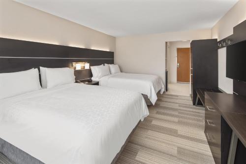 a hotel room with two beds and a desk at Holiday Inn Express & Suites - Hardeeville-Hilton Head by IHG in Hardeeville