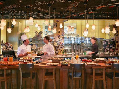 a group of chefs preparing food in a restaurant kitchen at Mama Shelter Bordeaux Centre in Bordeaux