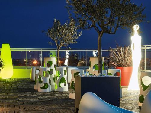 a rooftop deck with plants and lights at night at Ibis Styles Hyères Rooftop & Spa in Hyères
