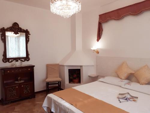 - une chambre avec un lit, un miroir et un lustre dans l'établissement GrappaLand, à Crespano del Grappa