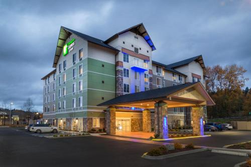 a hotel building with a car parked in a parking lot at Holiday Inn Express & Suites - Seattle South - Tukwila by IHG in Tukwila