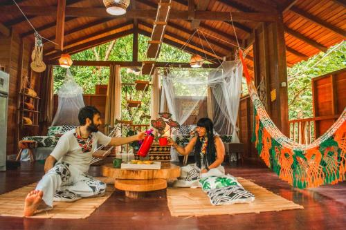 a man and woman sitting on the floor in a room at CASA DA ARVORE, sonho na Amazônia, 2min a pé da praia in Alter do Chao