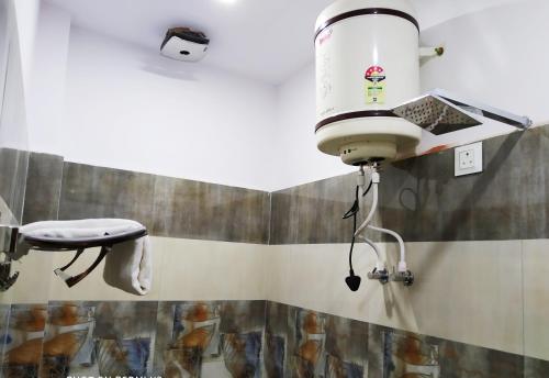 a bathroom with a hair dryer on the wall at Hotel vinayak inn in Haridwār