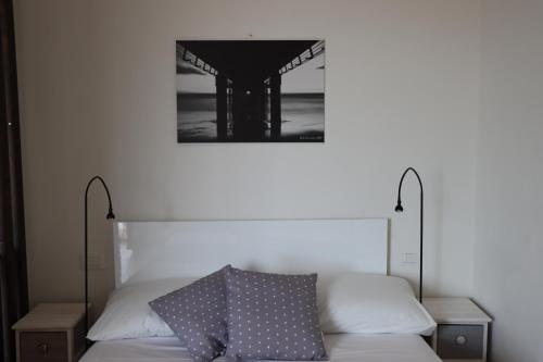 a bedroom with a bed with a picture on the wall at Myricae in Viareggio