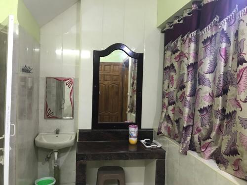 a bathroom with a sink and a toilet and a mirror at Rehoboth Home Stay in Kanyakumari