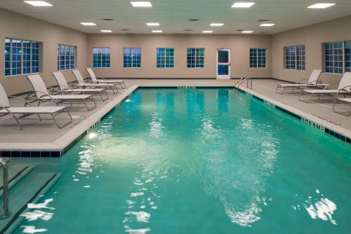 a swimming pool with chairs and a pool at Staybridge Suites - Pecos by IHG in Pecos