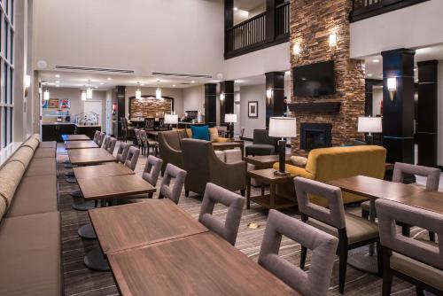 a restaurant with tables and chairs and a fireplace at Staybridge Suites - Pecos by IHG in Pecos