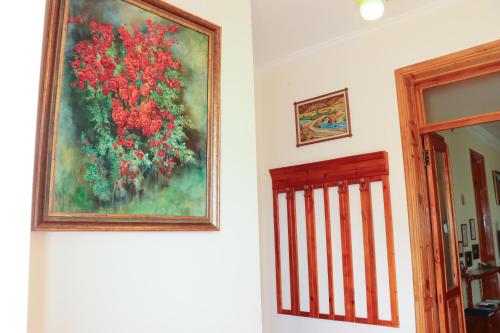 a painting of red flowers on a wall next to a door at Guest house Nataly in Yeghegnadzor