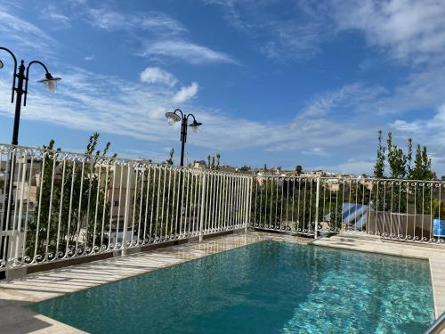 a metal fence with a swimming pool and a fence at Lulu Boutique Hotel in Żebbuġ