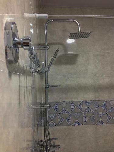 a shower in a bathroom with a shower head at Guest House Maradona in Sighnaghi