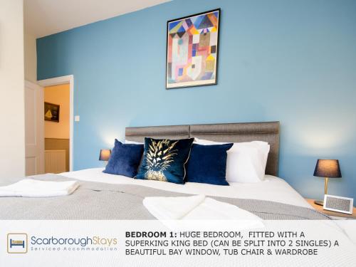 een slaapkamer met een bed met blauwe muren bij Scarborough Stays - Victorian Townhouse - 5 Bedrooms - SLEEPS 9 in Scarborough