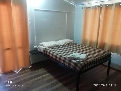 Cama pequeña en habitación con cortinas naranjas en Habitación Dalian, en Termas de Guaviyú