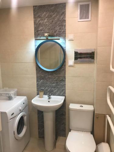 a bathroom with a sink and a toilet and a mirror at Biliūno studio in Anykščiai