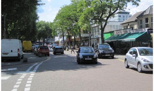 a busy city street with cars driving down the road at Rooftops Apartment in Bletchley