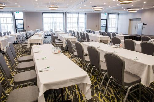 a conference room with white tables and chairs at Holiday Inn Hotel & Suites Calgary South - Conference Ctr by IHG in Calgary