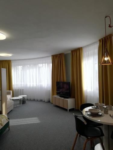 a living room with a tv and a table with chairs at Apartment MyMara No3 in Bešeňová