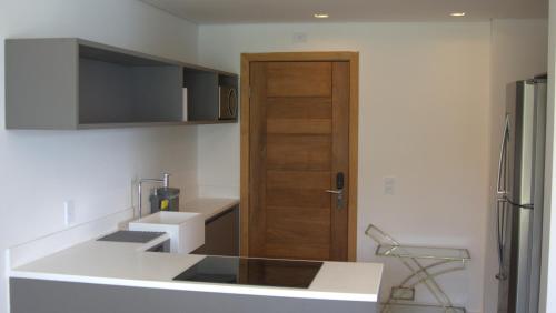 a kitchen with a wooden door and a refrigerator at Wyndham Ilhabela Casa Di Sirena in Ilhabela