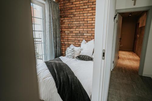 a bed in a room with a brick wall at THE LOFT - Garncarska 1 in Piotrków Trybunalski