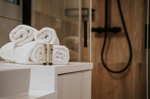 stos ręczników na ladzie w łazience w obiekcie THE LOFT - Garncarska 1 w Piotrkowie Trybunalskim