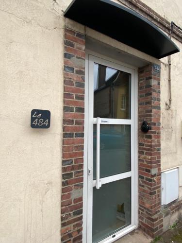 a door to a brick building with a sign on it at Maison de ville de 55m2 refait à neuf in Verneuil d’Avre et d’Iton