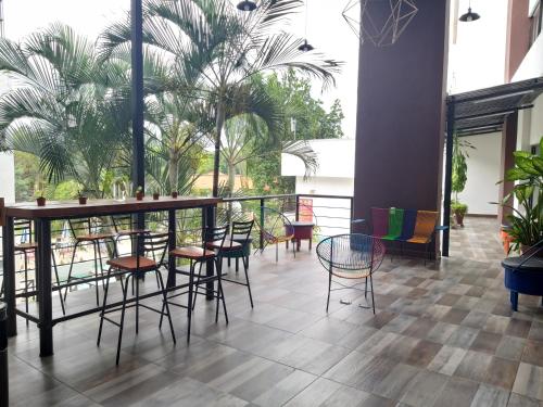 a restaurant with a table and chairs and palm trees at Hotel D Marco Exxpres in Palenque