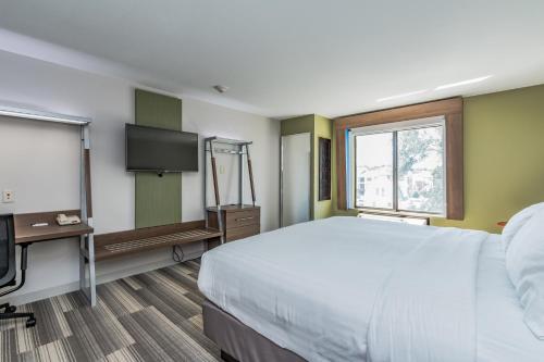 a hotel room with a bed and a flat screen tv at Holiday Inn Express & Suites - South Bend - Notre Dame Univ. in South Bend