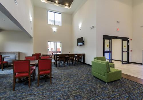 a waiting room with chairs and tables and a tv at Holiday Inn Express & Suites - South Bend - Notre Dame Univ. in South Bend