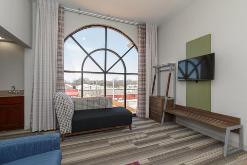 a living room with a large window and a tv at Holiday Inn Express & Suites - South Bend - Notre Dame Univ. in South Bend